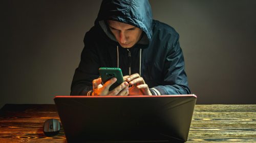 hacker avec son téléphone et son pc