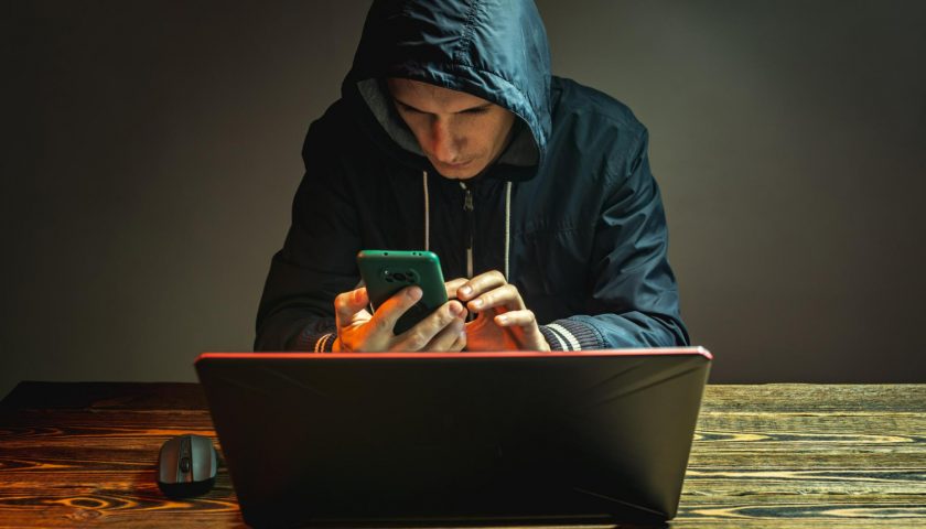 hacker avec son téléphone et son pc
