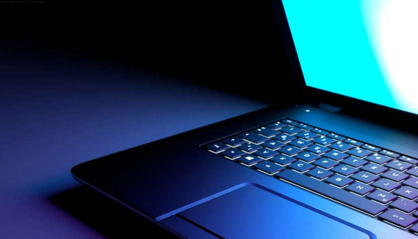 clavier de pc portable éclairé par l'écran dans la pénombre