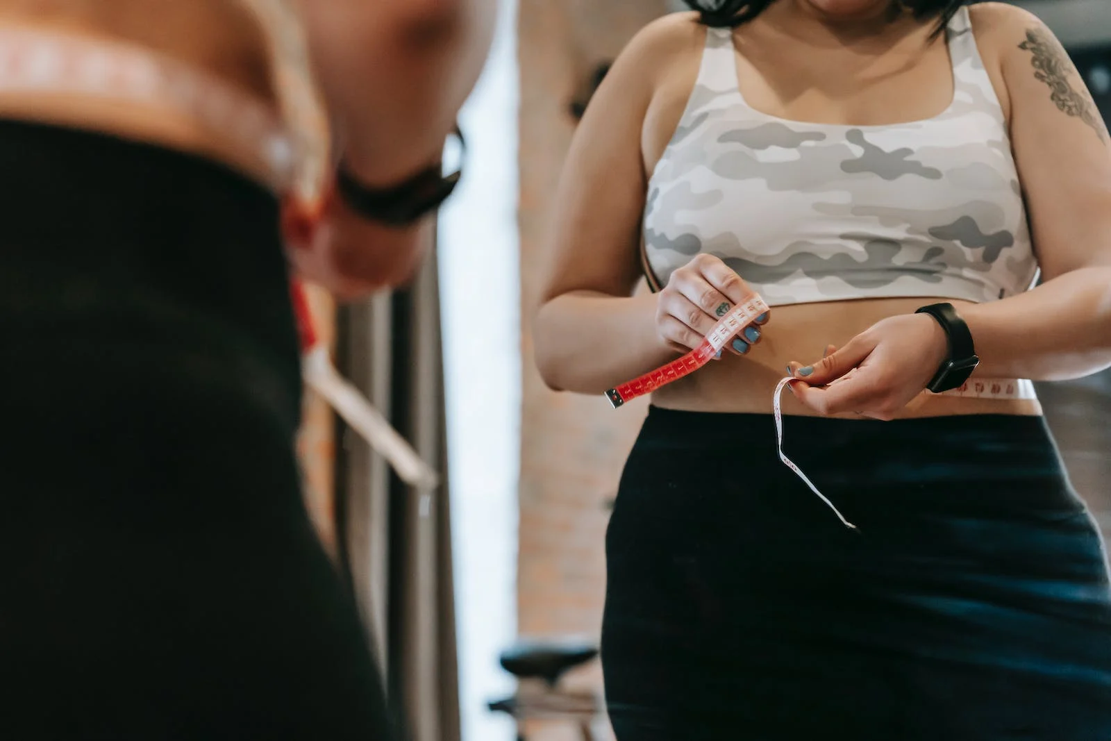 femme devant un miroir avec une règle de mesure du corps