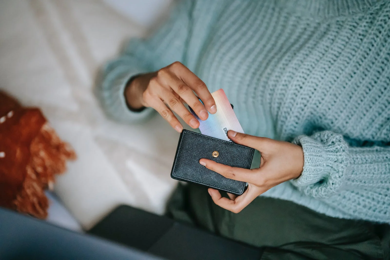 une femme sortant sa carte bancaire de son portefeuille